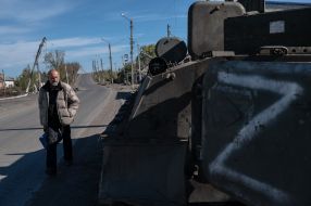 Местный житель проходит возле военной техники оккупантов