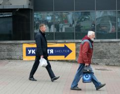 Люди проходят возле указателя "Укрытие"