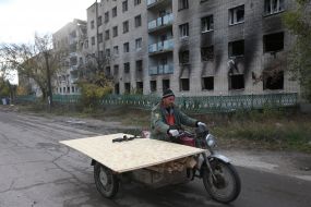 Мужчина везет фанеру для восстановления поврежденного обстрелами дома в деоккупированном поселке Архангельское (Херсонская область)