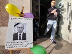 Объявление с портретом путина с траурной лентой на входе одного из баров