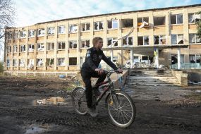 Ninth grader Mykyta near destroyed school in the village of Lyubimivka (Kherson region)