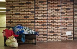 A homeless woman sleeps in an underpass