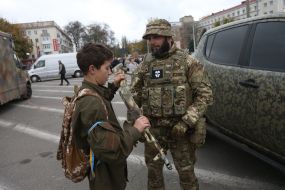 Мальчик с желто-голубой лентой возле украинского военного в деоккупированном Херсоне
