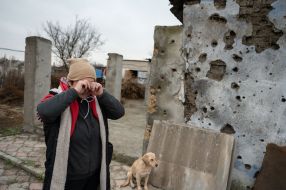 Местная жительница возле разрушенного дома в селе Посад-Покровское