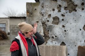 Местная жительница возле разрушенного дома в селе Посад-Покровское