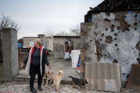 Местная жительница возле разрушенного дома в селе Посад-Покровское