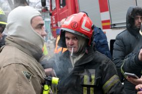 Lifeguard near a house destroyed by rocket fire