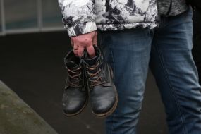 A man holds shoes in his hands