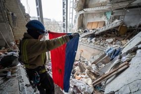 The rescuer holds in his hands the found flag of the Ukrainian SSR