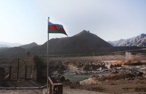 The national flag of Azerbaijan on the border with Iran