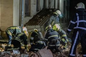 Rescuers near a residential building dilapidated as a result of shelling