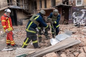 Rescuers near a residential building dilapidated as a result of shelling