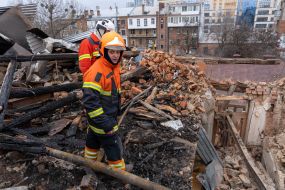 Rescuers on the roof of residential building dilapidated as a result of shelling