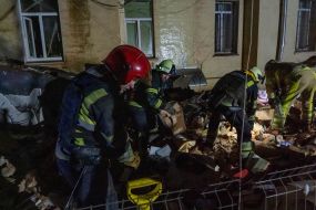 Rescuers near a residential building dilapidated as a result of shelling