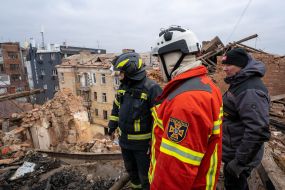 Rescuers on the roof of residential building dilapidated as a result of shelling