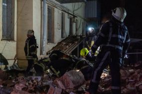 Rescuers near a residential building dilapidated as a result of shelling