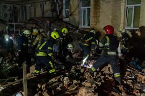 Rescuers near a residential building dilapidated as a result of shelling