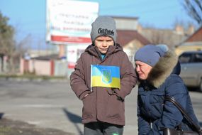 Woman with a child near a memorial stone