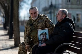 A man with a photo of a dead soldier