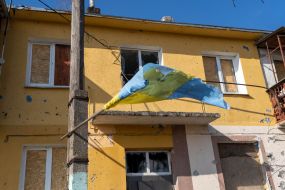 Flag of Ukraine near the house damaged by explosions