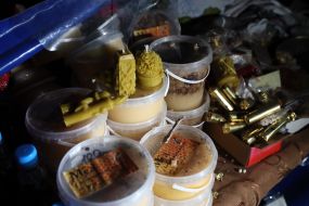 Honey, candles in a tent near the shelled monastery of the UOC MP monastery