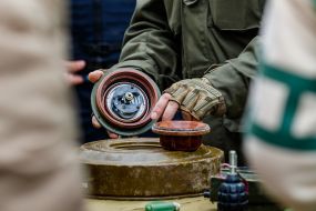 A soldier demonstrates the design of an anti-tank mine