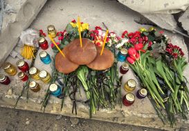 Квіти, лампадки біля зруйнованої будівлі профліцею у Ржищеві