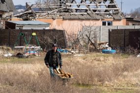 A local resident carries firewood in the village of Russian Tishki, Kharkov region