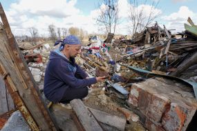 A local resident holds in his hands a piece of the rocket that destroyed his house, in the village of Russian Tishki, Kharkov region
