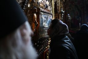 A woman kisses the icon