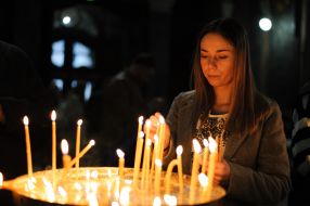 A woman puts a candle