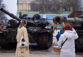 People with Easter baskets near destroyed Russian military equipment on Mykhailivska Square