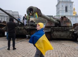 A boy with a flag of Ukraine near destroyed Russian military equipment on Mykhailivska Square