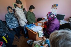 Local residents receive humanitarian aid in the form of seeds for the garden
