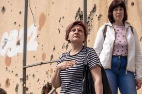 Women listen to the national anthem of Ukraine