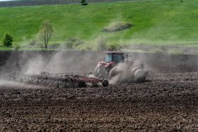 A tractor plows a field