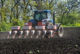 Tractor spreads fertilizer on the field