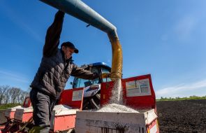 Робочий завантажує добрива в культиватор