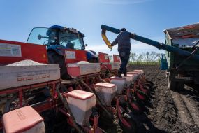 Робочий завантажує добрива в культиватор