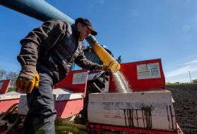 Робочий завантажує добрива в культиватор