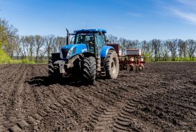 Трактор вносить добрива на поле