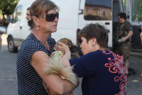 A woman holds a dog in her arms