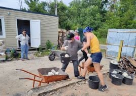 Volunteers dismantle a destroyed house in the village of Moschun, Kyiv region