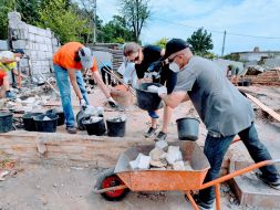 Volunteers dismantle a destroyed house in the village of Moschun, Kyiv region