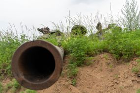 The turret of a blown-up tank lies in a field in the Kharkiv region