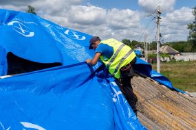 Volunteers are repairing the roof of a destroyed house