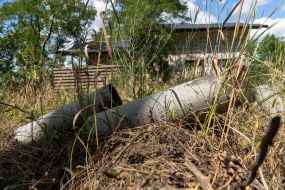 Artillery shells lie near an unfinished house