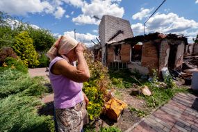A woman near her destroyed house