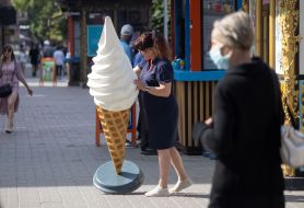 A woman moves an ice cream mockup near a shopping kiosk