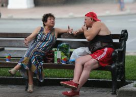 People chat while sitting on a bench in Kyiv